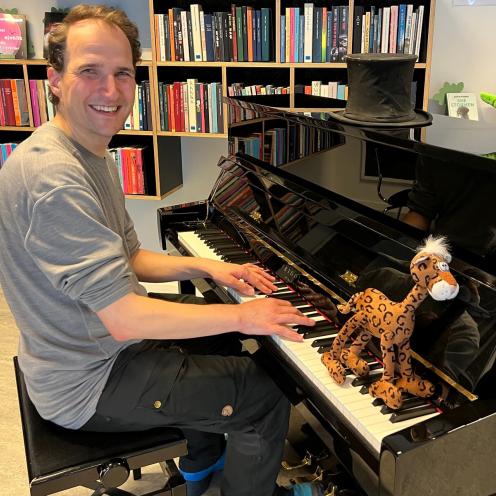 Entertainer Martin Emil Kron foran et klaver sammen med sine bamser Dino og Pjuske.